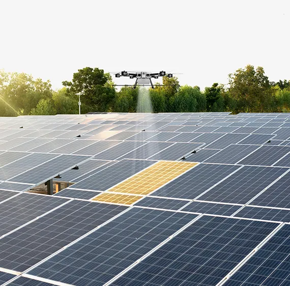 A drone doing an inspection and thermal scan of a solar panel array, trees in the background.