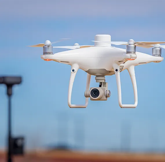 White quadcopter drone in flight.