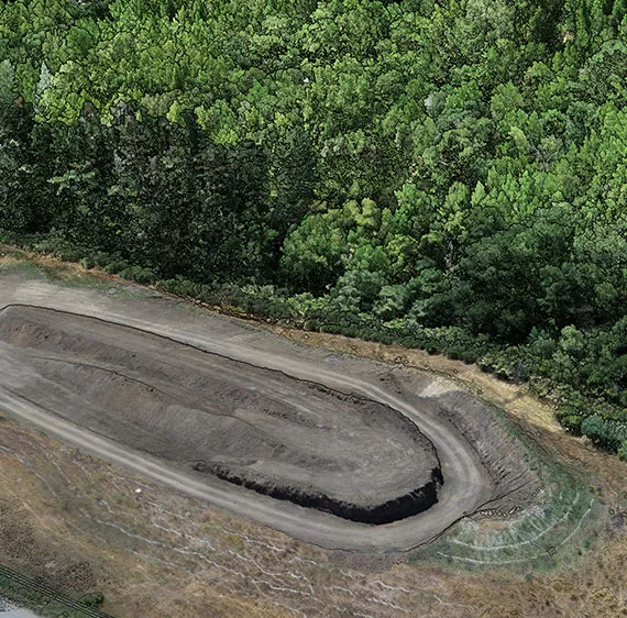 Aerial photo of excavated land near a forrest.