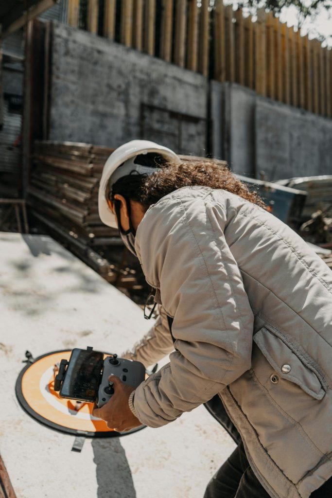 A drone pilot in a construction area, controlling a drone outdoors in Guatemala.